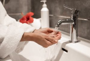 une femme utilisant le robinet de la salle de bain