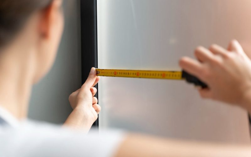 A Man Installing a Wall-Mounted Mirror