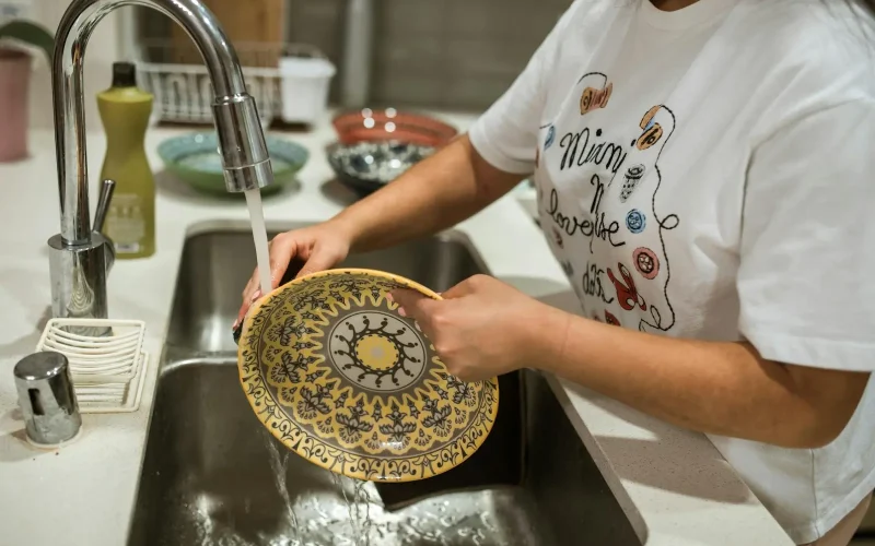 A woman was washing dishes in a double-bowl sink